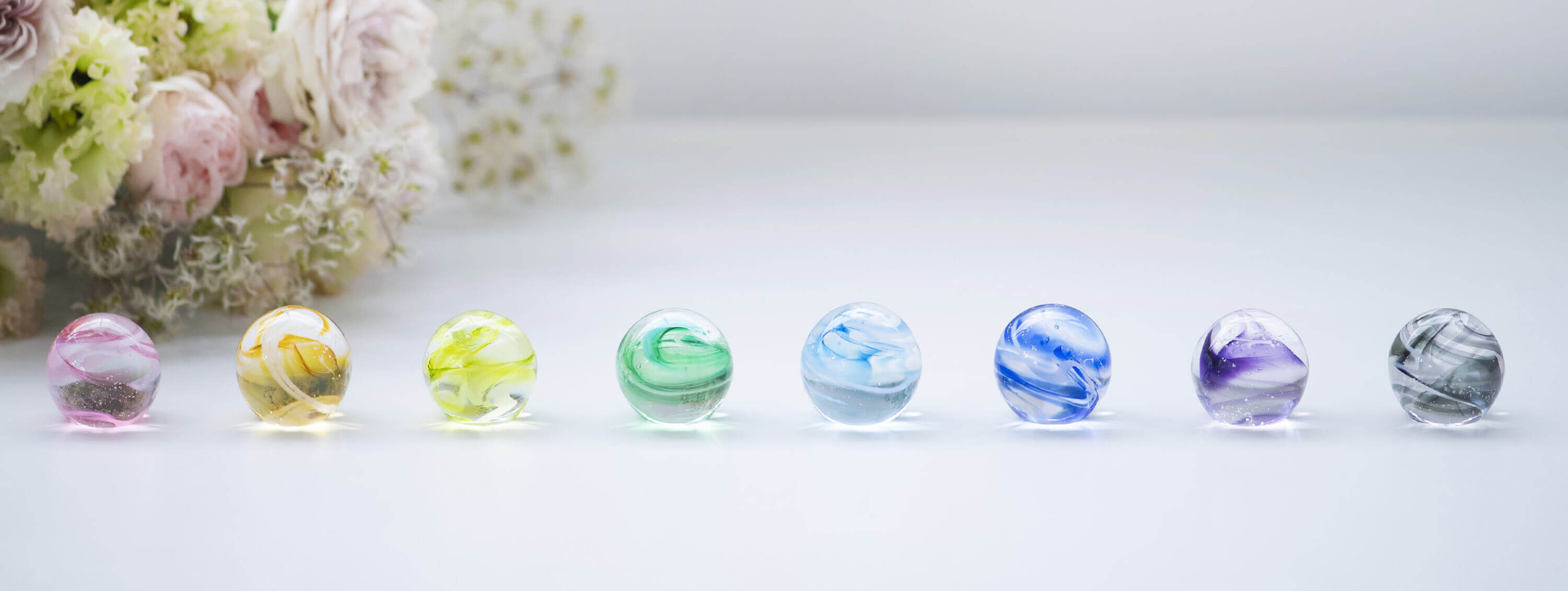 花束と様々な色の遺骨ガラスSoraca